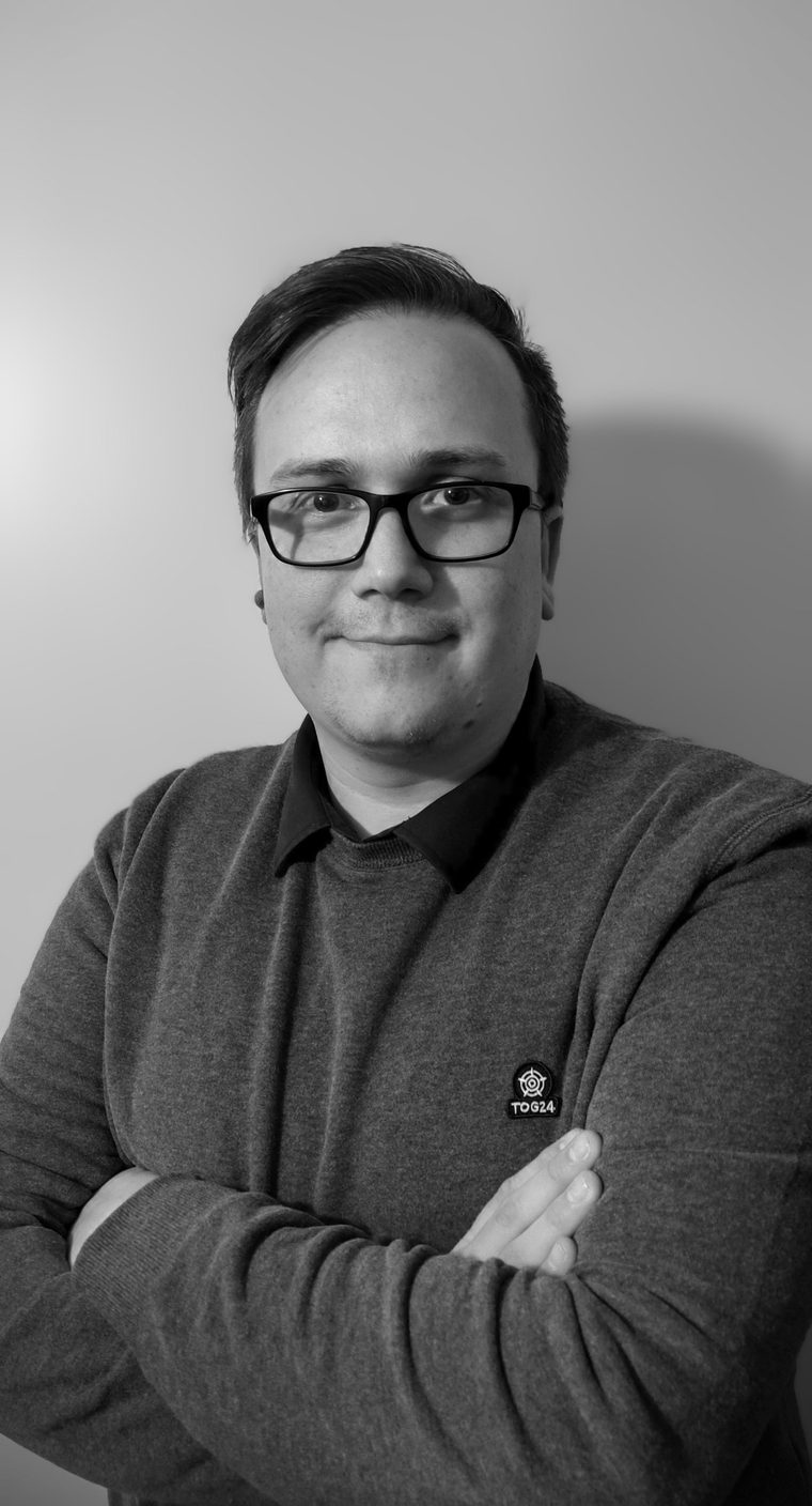Adam Plummer, arms folded, smiling